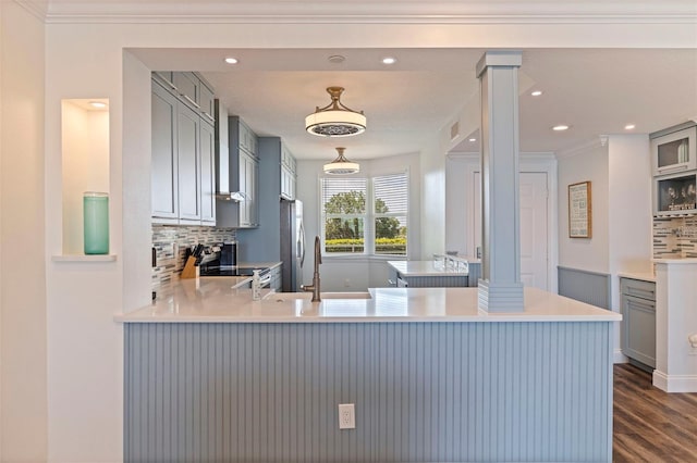 kitchen featuring gray cabinets, appliances with stainless steel finishes, backsplash, dark wood-type flooring, and ornamental molding