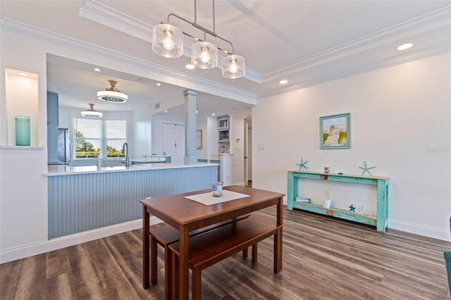 dining space featuring wood finished floors, ornamental molding, baseboards, ornate columns, and recessed lighting