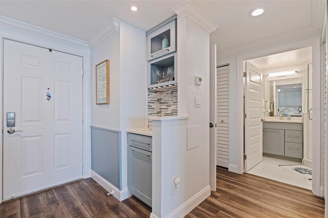 hallway with ornamental molding, wood finished floors, wainscoting, and recessed lighting