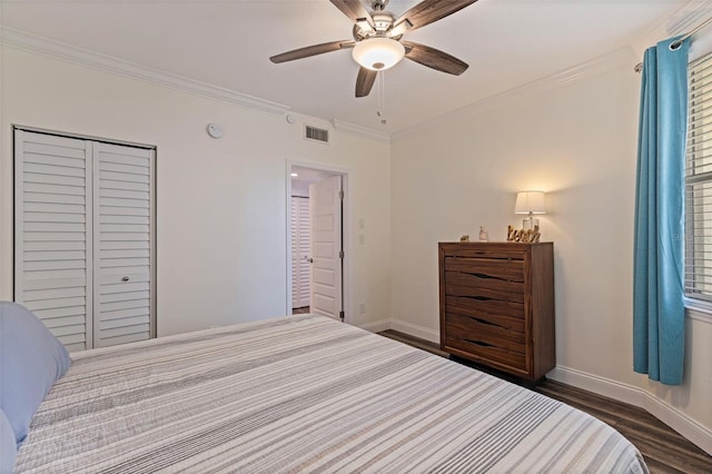 bedroom featuring crown molding, baseboards, dark wood-style flooring, a ceiling fan, and a closet