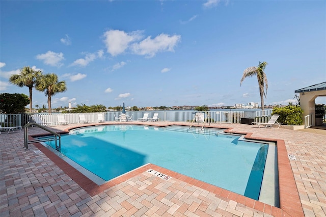 community pool with fence and a patio area