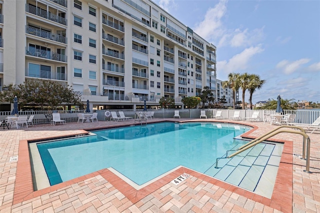 community pool featuring fence and a patio