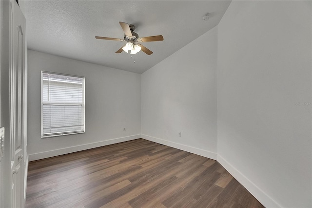 spare room with dark wood-style floors, ceiling fan, baseboards, lofted ceiling, and a smoke detector
