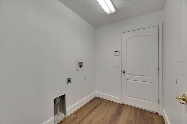 washroom with electric dryer hookup, hookup for a washing machine, wood finished floors, and baseboards
