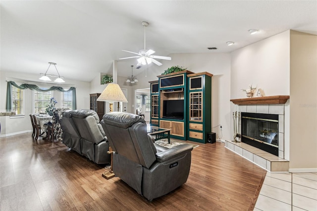 1202 Williams Rd, Plant City, FL 33565 - living room featuring vaulted ceiling, a fireplace, ceiling fan, wood finished floors, and baseboards