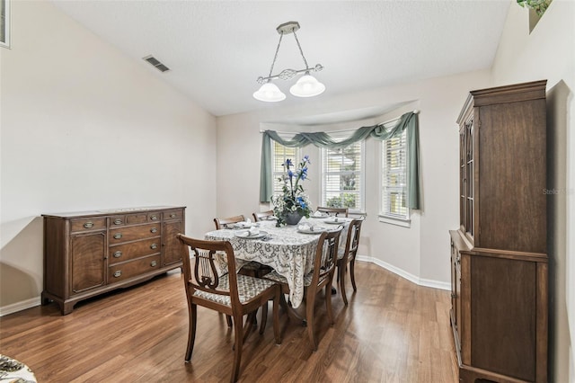 1202 Williams Rd, Plant City, FL 33565 - dining room featuring wood finished floors, baseboards, lofted ceiling, and a chandelier