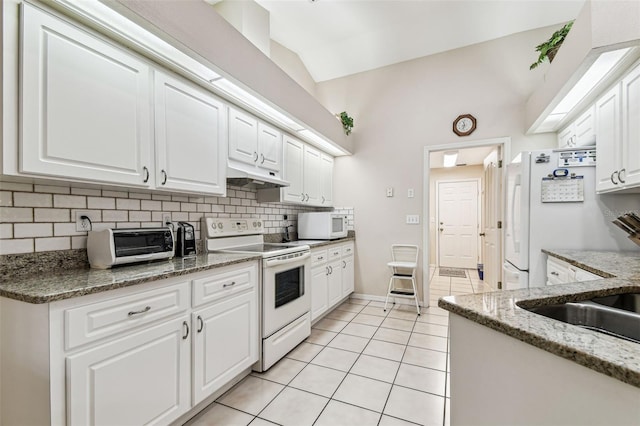 1202 Williams Rd, Plant City, FL 33565 - kitchen with white appliances, under cabinet range hood, light tile patterned floors, decorative backsplash, and white cabinetry