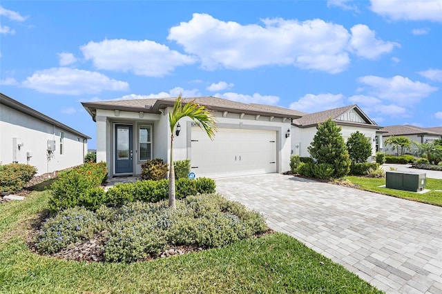 10418 Spring Tide Way, Parrish, FL 34219 - ranch-style house featuring decorative driveway, stucco siding, and a garage