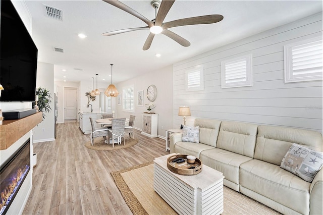 10418 Spring Tide Way, Parrish, FL 34219 - living room with ceiling fan, baseboards, light wood-type flooring, recessed lighting, and wood walls