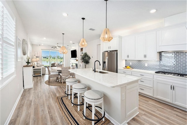 10418 Spring Tide Way, Parrish, FL 34219 - kitchen featuring stainless steel appliances, a sink, tasteful backsplash, light wood-style floors, and recessed lighting