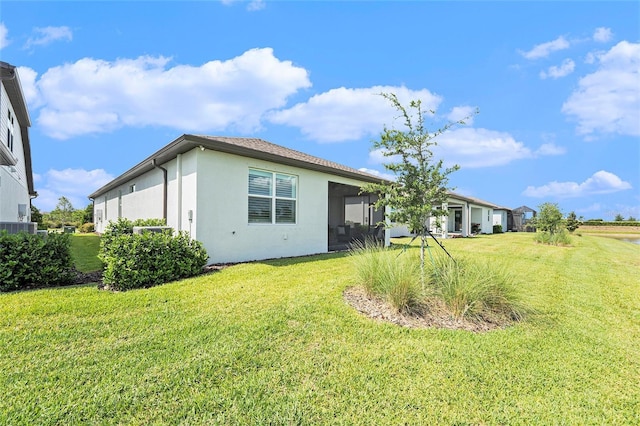 10418 Spring Tide Way, Parrish, FL 34219 - rear view of property featuring stucco siding, a yard, and central AC unit