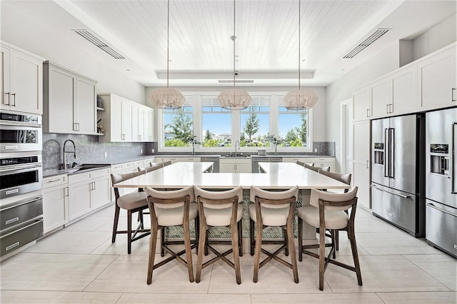 10418 Spring Tide Way, Parrish, FL 34219 - kitchen featuring appliances with stainless steel finishes, a chandelier, a sink, backsplash, and wood ceiling