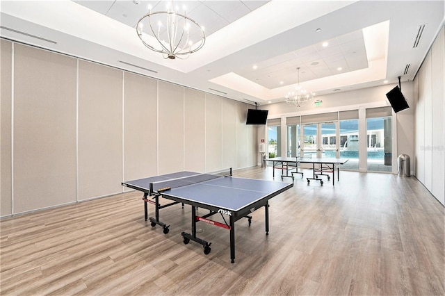 10418 Spring Tide Way, Parrish, FL 34219 - recreation room featuring a chandelier, a tray ceiling, light wood-style floors, recessed lighting, and a towering ceiling