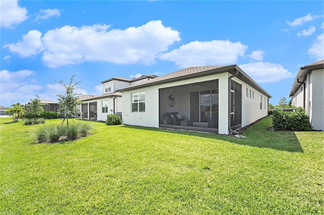 10418 Spring Tide Way, Parrish, FL 34219 - rear view of house with a sunroom, a lawn, and stucco siding