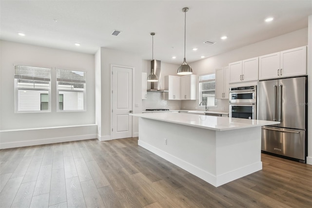 7232 Sutton Ln, Sarasota, FL 34240 - kitchen with appliances with stainless steel finishes, wall chimney range hood, a sink, a kitchen island, and dark wood-style floors