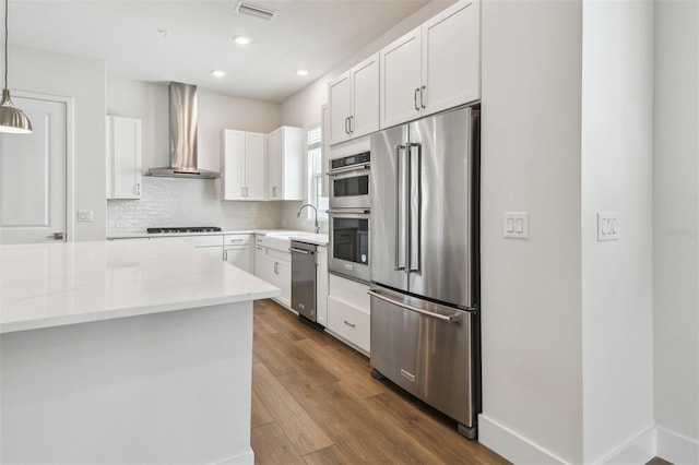 7232 Sutton Ln, Sarasota, FL 34240 - kitchen with stainless steel appliances, wall chimney exhaust hood, white cabinets, tasteful backsplash, and dark wood finished floors