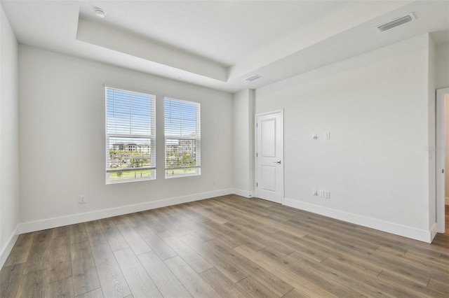 7232 Sutton Ln, Sarasota, FL 34240 - unfurnished room featuring a raised ceiling, baseboards, wood finished floors, and a smoke detector