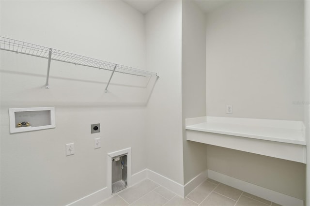 7232 Sutton Ln, Sarasota, FL 34240 - clothes washing area featuring hookup for an electric dryer, washer hookup, baseboards, light tile patterned flooring, and a desk