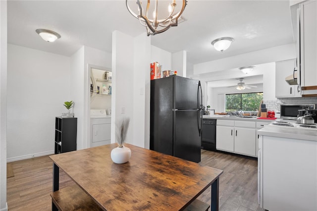 16504 Lake Brigadoon Cir, Tampa, FL 33618 - kitchen with black appliances, a sink, wood finished floors, washing machine and clothes dryer, and white cabinetry