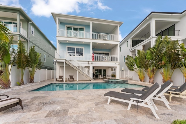 view of pool with a fenced backyard, stairs, a pool with connected hot tub, and a patio
