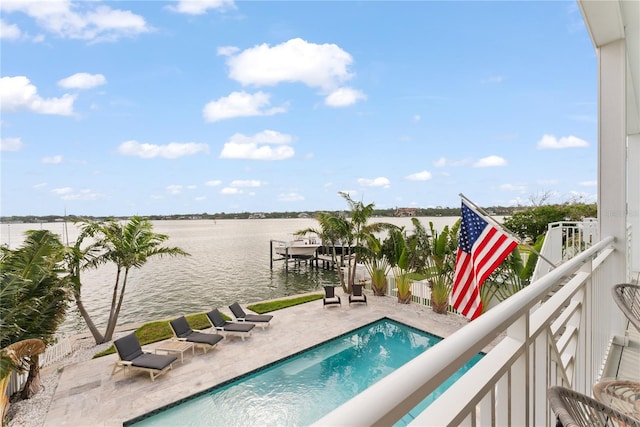 view of pool featuring a water view, a dock, boat lift, and a patio