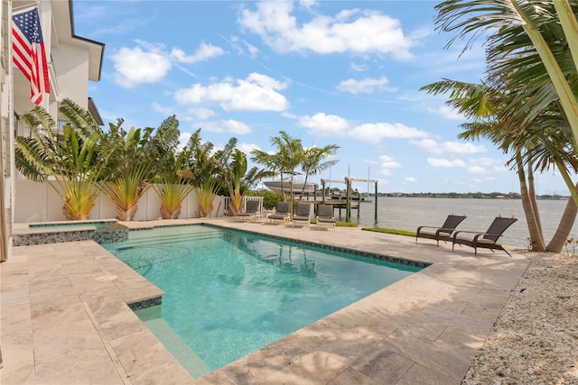 view of pool featuring a patio area, a fenced backyard, a pool with connected hot tub, and a water view