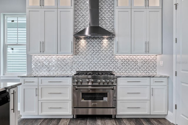 kitchen with stainless steel appliances, wall chimney range hood, white cabinetry, and glass insert cabinets