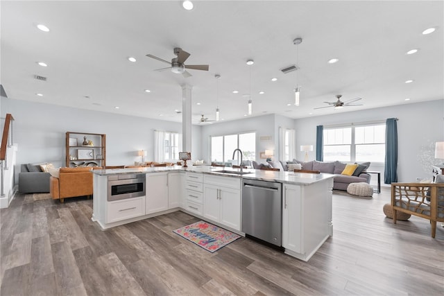 kitchen featuring open floor plan, stainless steel dishwasher, a ceiling fan, a sink, and recessed lighting