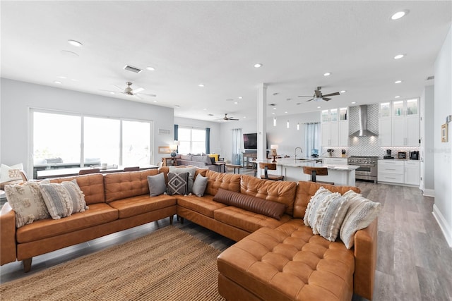 living room with ceiling fan, light wood finished floors, recessed lighting, and baseboards