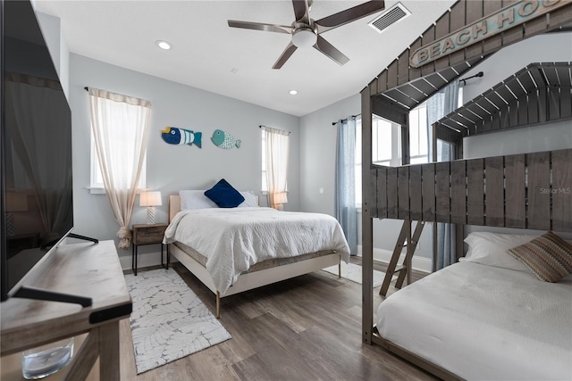 bedroom featuring multiple windows, wood finished floors, baseboards, recessed lighting, and vaulted ceiling