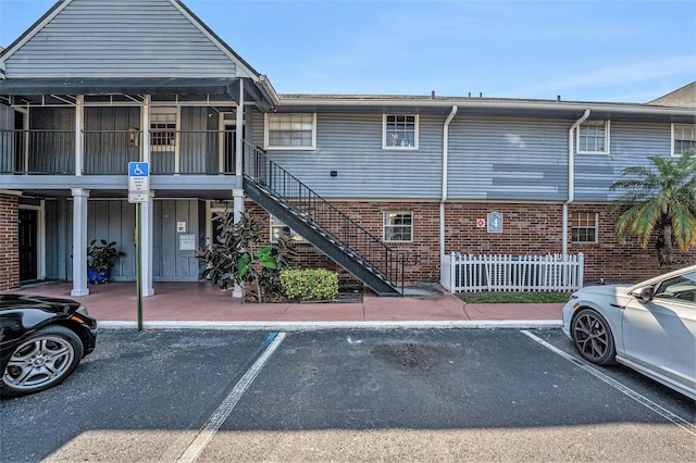 200 Country Club Dr Unit 403, Largo, FL 33771 - view of property featuring uncovered parking, stairway, and fence