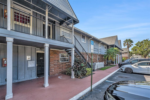 200 Country Club Dr Unit 403, Largo, FL 33771 - view of property exterior with uncovered parking, brick siding, and stairs