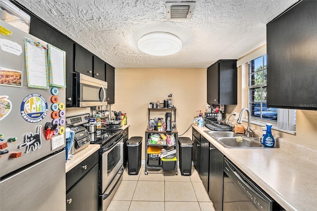 200 Country Club Dr Unit 403, Largo, FL 33771 - kitchen featuring stainless steel appliances, a sink, dark cabinetry, light countertops, and light tile patterned floors