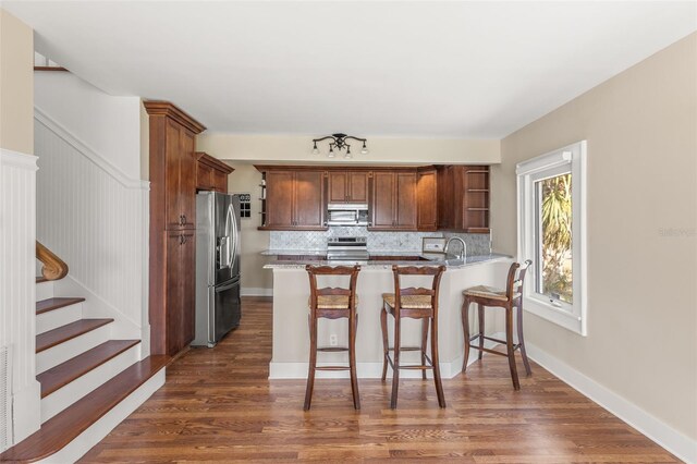 308 Chauncey Ave, Bradenton, FL 34208 - kitchen featuring a sink, a peninsula, stainless steel appliances, open shelves, and decorative backsplash