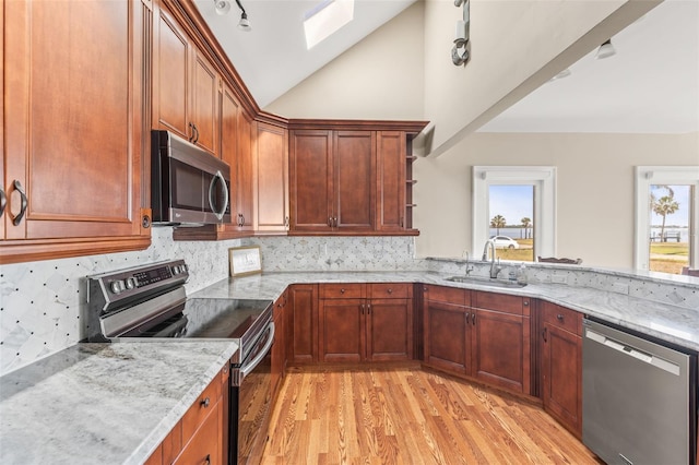 308 Chauncey Ave, Bradenton, FL 34208 - kitchen with a sink, open shelves, light wood-style floors, appliances with stainless steel finishes, and vaulted ceiling with skylight