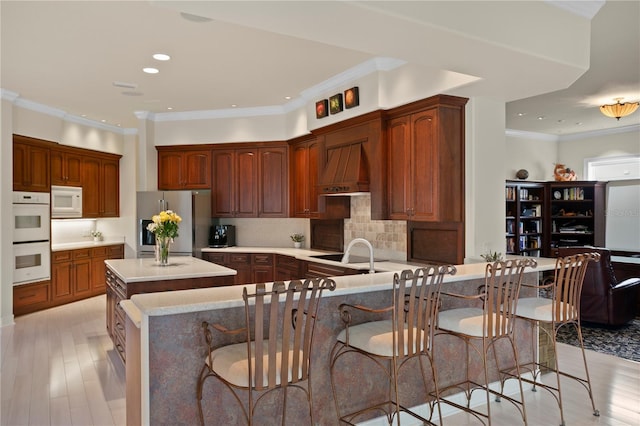 19815 Sea Rider Way, Lutz, FL 33559 - kitchen featuring white appliances, custom exhaust hood, a sink, light wood-type flooring, and light countertops