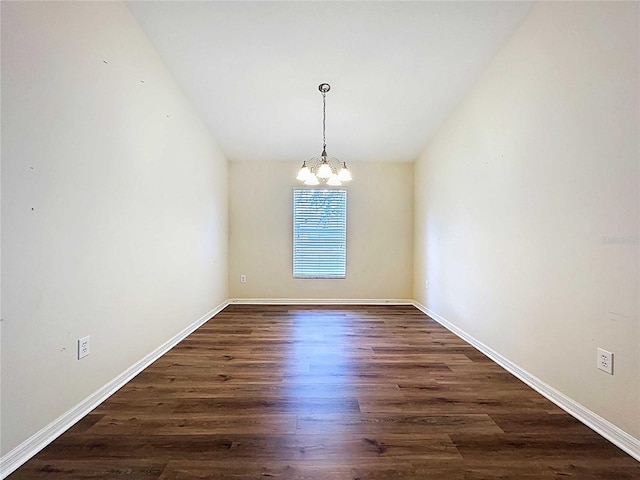 7504 Turtle View Dr, Ruskin, FL 33573 - empty room featuring a chandelier, dark wood finished floors, and vaulted ceiling