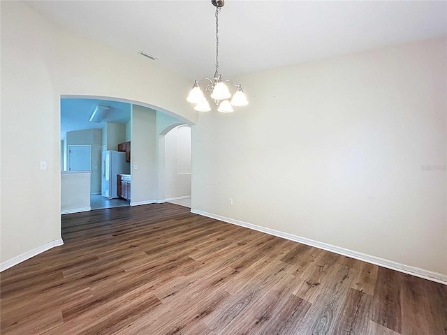 7504 Turtle View Dr, Ruskin, FL 33573 - spare room with a chandelier, arched walkways, and wood finished floors