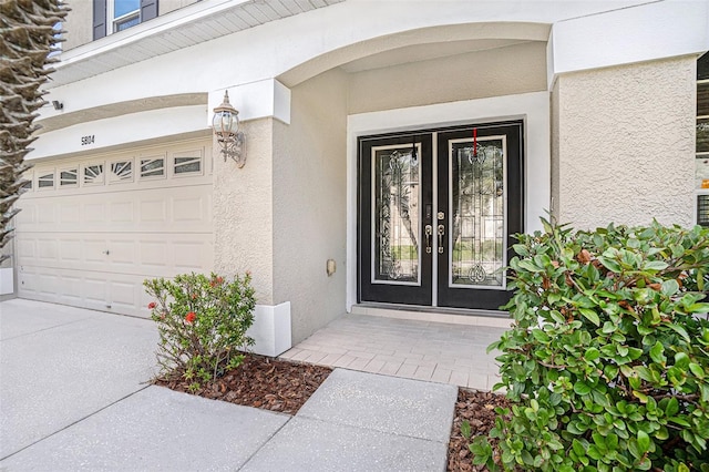 5804 Butterfield St, Riverview, FL 33578 - view of exterior entry featuring stucco siding, french doors, and a garage