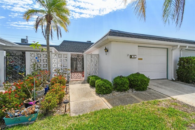 ranch-style home with stucco siding, concrete driveway, a gate, an attached garage, and fence