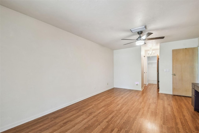 spare room featuring a ceiling fan, light wood-type flooring, and baseboards