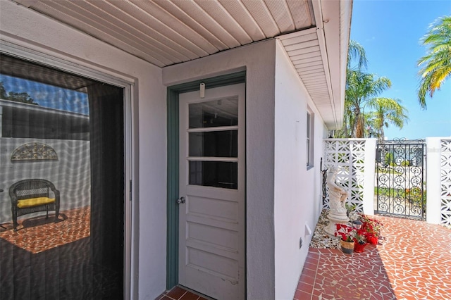 property entrance with stucco siding and fence