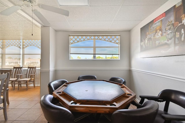 playroom with a drop ceiling, ceiling fan, and light tile patterned floors