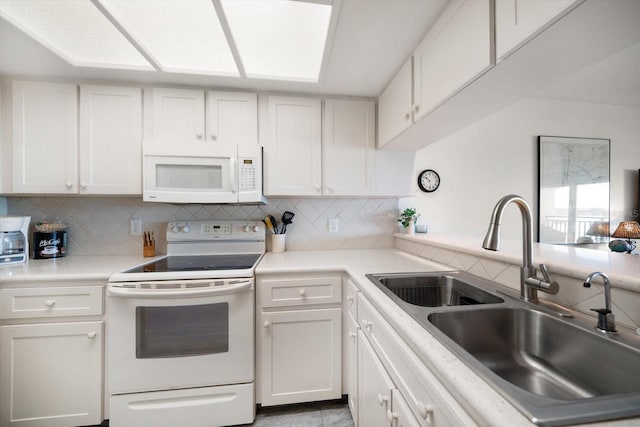 kitchen with a sink, white appliances, decorative backsplash, light countertops, and white cabinets