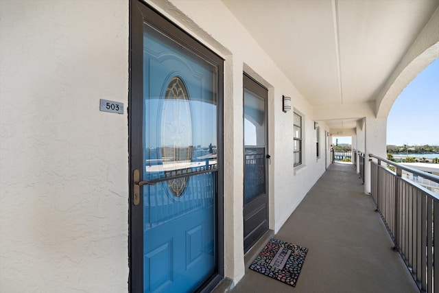 property entrance with stucco siding and a balcony