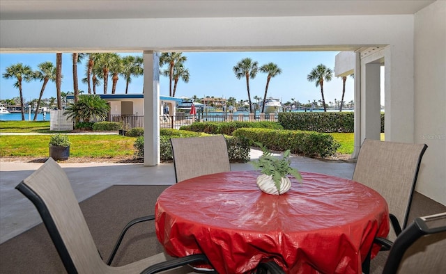 view of patio / terrace with a water view and fence