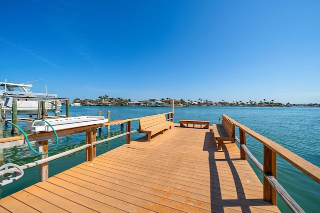 dock area featuring boat lift and a water view