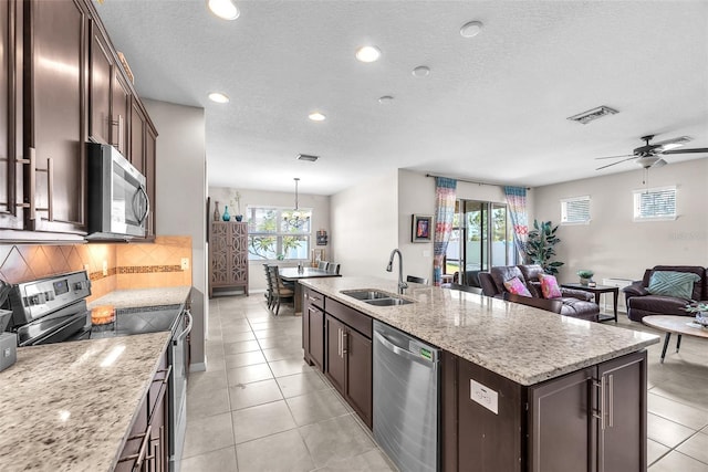 11606 Kilkenny Coral Dr, Riverview, FL 33579 - kitchen featuring stainless steel appliances, a sink, dark brown cabinetry, light tile patterned flooring, and recessed lighting