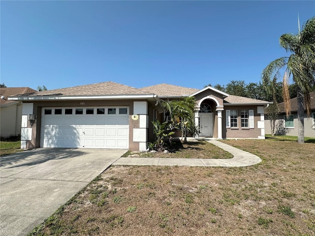single story home featuring an attached garage, stucco siding, driveway, and a front yard