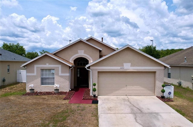 24305 Denali Ct, Lutz, FL 33559 - single story home with a garage, driveway, brick siding, and stucco siding